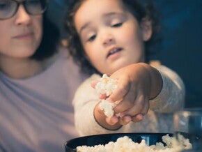 Niña pequeña comiendo un snack.
