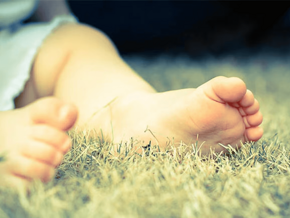 Cómo identificar el pie plano en niños Pies de niño pequeño descalzo sobre césped seco al aire libre.