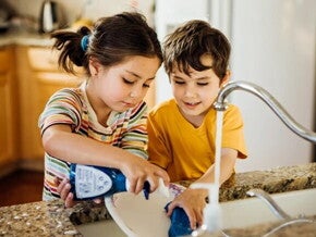 Niño y niña lavando los platos