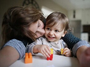 Mujer adulta y niña pequeña jugando con bloques