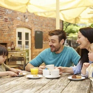 Una familia y dos niños felices sentados en la mesa