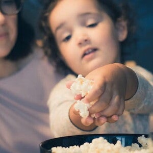 Niña pequeña comiendo un snack.