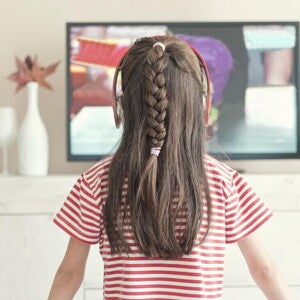 Niña pequeña viendo la televisión.