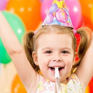 Guía para fiestas infantiles Niña pequeña feliz en una fiesta infantil con globos de colores
