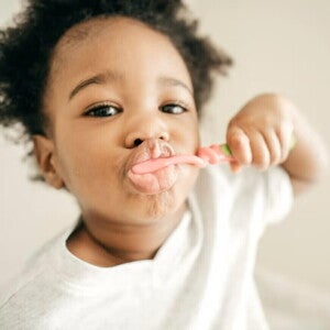 Niño pequeño cepillándose los dientes para evitar caries.