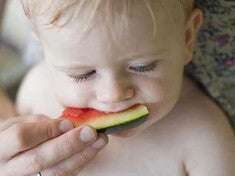 Bebé siendo alimentado con una sandía