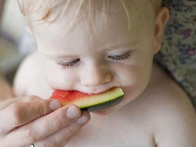 Bebé siendo alimentado con una sandía