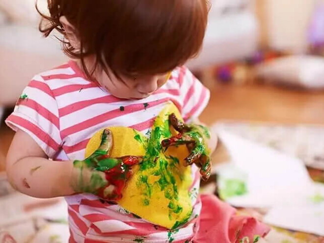 Actividades sensoriales para niños de 12 a 24 meses niña jugando con pintura