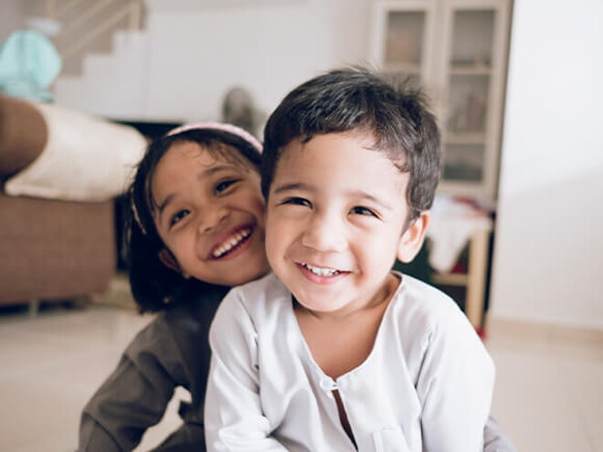 Identifica cuál es la diferencia entre los gemelos y los mellizos. Dos mellizos felices jugando en casa.