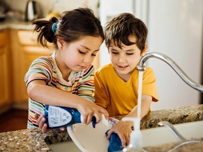 Niño y niña lavando los platos