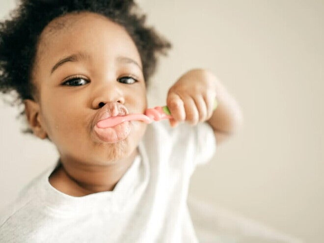 Niño pequeño cepillándose los dientes para evitar caries.