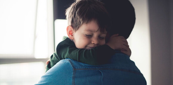 Un niño feliz después de que su papá le ayudo a descongestionar su nariz. Un niño feliz después de que su papá le ayudo a descongestionar su nariz.