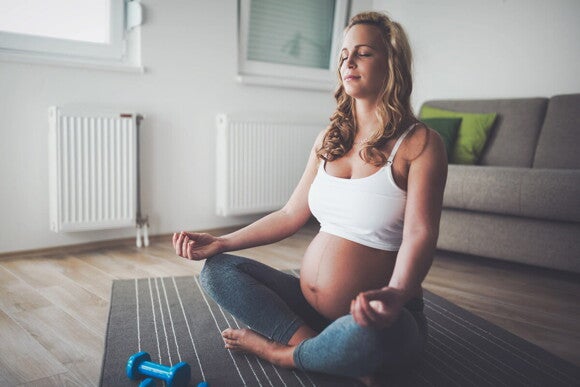Yoga para embarazadas Mujer embarazada sentada meditando