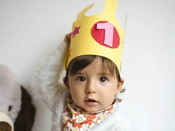 Niña pequeña con una corona de cumpleaños.