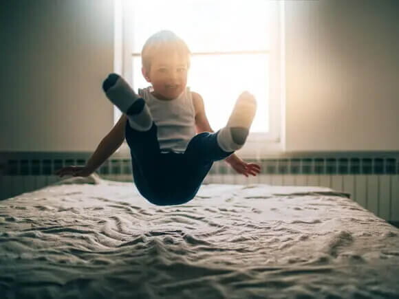 Estimulación temprana para niños niño saltando sobre la cama