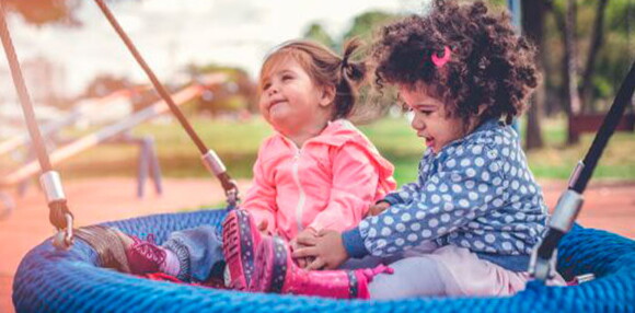 Los coche para niños permiten que socialicen con los demás. Dos niñas en el parque jugando.