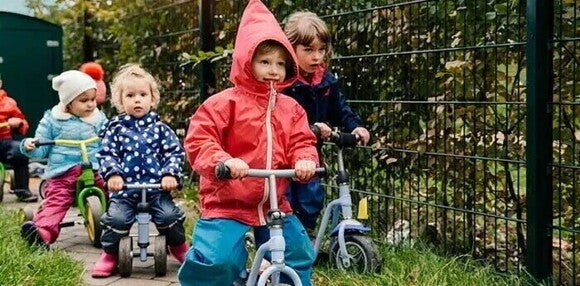 Importancia de la motricidad gruesa Niños pequeños en triciclos, desarrollando habilidades motoras gruesas